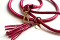 a pink dog leash in rolled leather with a tassel and crystals