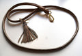 a beige dog leash in rolled leather with a tassel and crystals