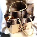 a cavalier king charles spaniel in a comfy leather dog carrier