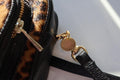 leopard leather dogmom bag, black lambs leather with leopard pony. With shoulder strap. One big compartment with zipper, one small compartment with zipper and hole for poopbags, one small compartment for treats, closes with magnet