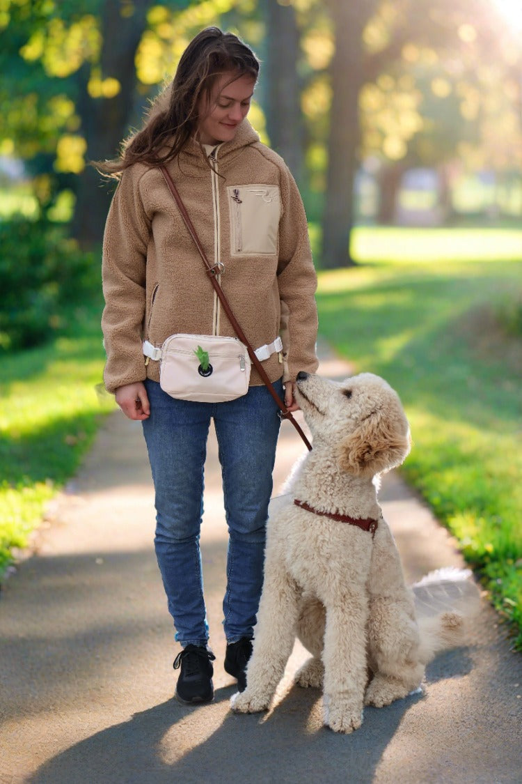 girl with her dog. she's wearing a dog mom fanny bag