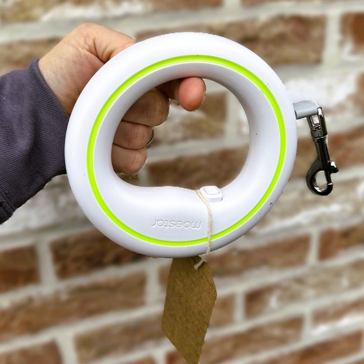  a hand holding a Handsfree Rollable Leash with one finger to show its lightness